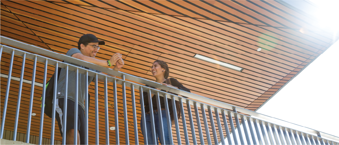 two students standing under a wooden ceiling